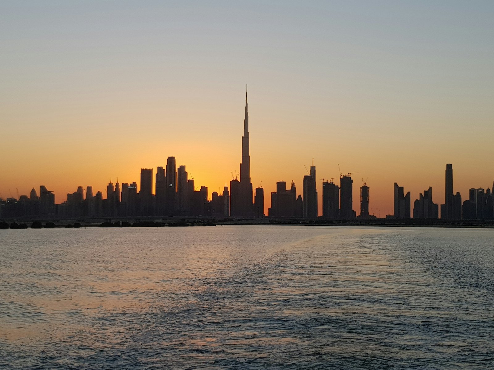 The Dubai skyline across the water at golden hour